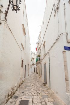 Wonderful wiew of the empty streets of old town Martina Franca with a beautiful houses painted in white. Nice day in a tourist town, Apulia, Italy.