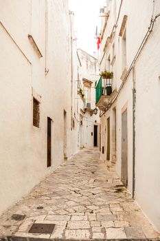 Alluring view of the empty streets of old town Martina Franca with a beautiful houses painted in white. Wonderful day in a tourist town, Apulia, Italy.