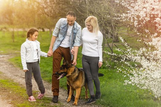 Young family with children and with dog having fun in nature.