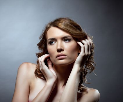 Young beautiful brunette woman fashion portait on gray background