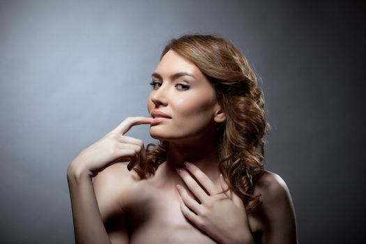 Pretty young woman bare portrait with finger on mouth