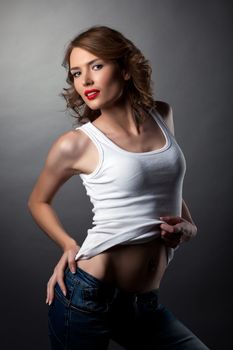 Sexy cute woman posing jeans and white tank top