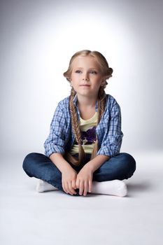 Studio portrait of pretty blonde girl sit in shirt