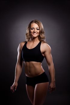 Young athletic woman body builder portrait in fitness costume