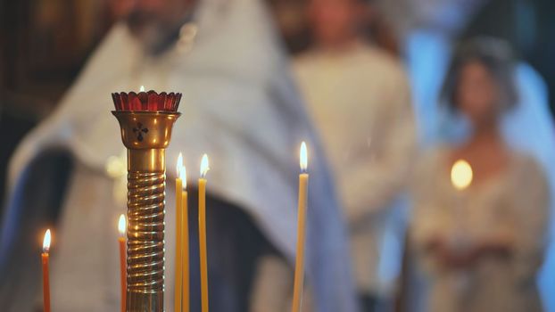 Burning candles in front of the priest at the wedding ceremony