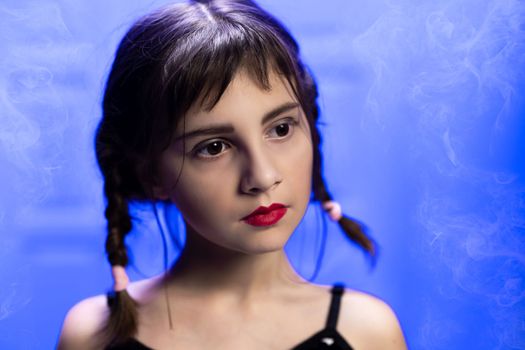 Portrait of girl in a Wednesday Addams style. Child girl with pigtails in a gothic style on a dark background. Fantasy gothic black-haired girl.