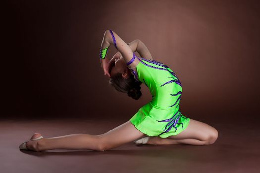 Dramatic kid in gymnast costume posing in dance