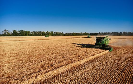 John Deere harvester works in the field. Combine Harvesting Wheat. Field field of cereals during harvesting. Modern equipment works. 07.07.22, Rostov region, Russia.