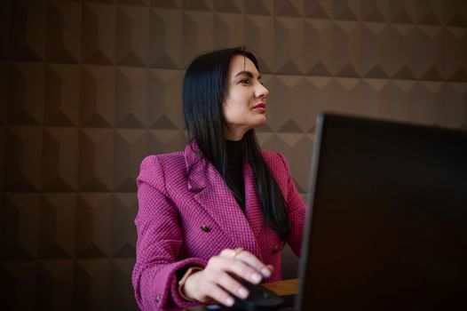 Confident, successful middle-aged woman, business lady, entrepreneur in casual clothes, working remotely on laptop at a cozy cafe interior. Online business, successful people, urban lifestyle concept