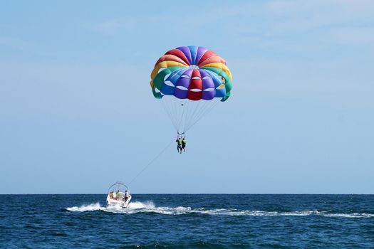 Varna, Bulgaria - September, 20, 2021: tourists fly on a multicolored parachute tied to a boat