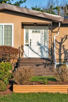 Main entrance of residential house with doorsteps on sunny day in winter