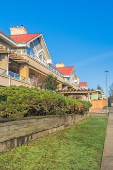 Residential building with red roofs and hedge row on land terrace.