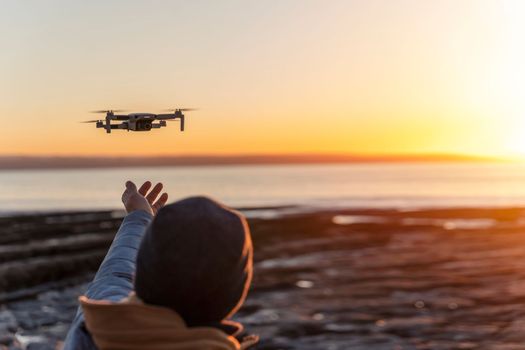 Bearded man using a drone with remote controller making photos and videos, having fun with new technology trends