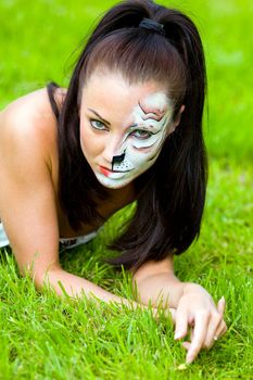 woman with face art on grass close up