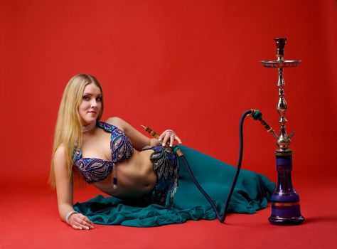 beauty young woman with hookah on red