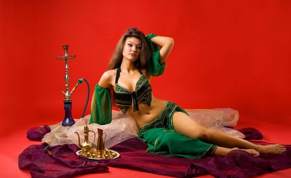beauty young woman with hookah on veil in red