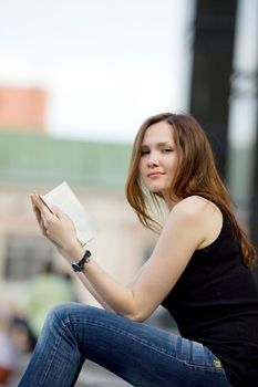 Woman with book and look at you in city