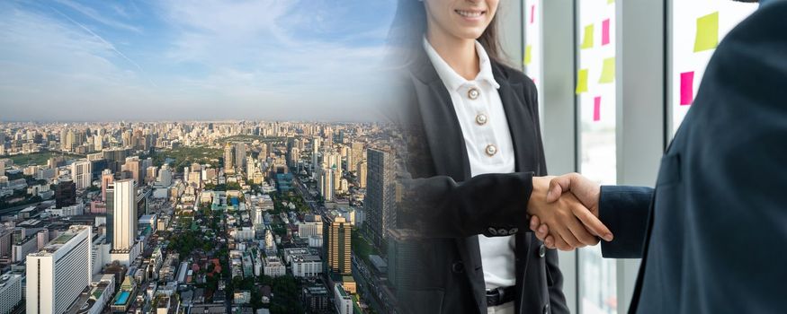 Business people handshake in corporate office in widen view showing professional agreement on a financial deal contract.