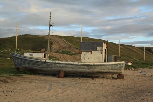 Old boat sitting on a beach in the arctic. Near Pond Inlet, Nunavut, Canada