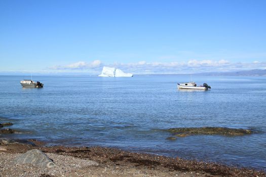 View of boats and a glacier in an inlet near the northern Inuit community of Pond Inlet in arctic Canada