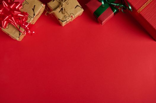 Christmas still life with gifts in the top of a red background. Copy ad space. Mockup, layout for promotional text. Boxing Day. Xmas and New Year's preparations. Packing presents. Web banner. Flat lay
