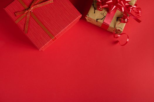 Beautiful cute Christmas gifts in the top of red background with copy advertising space. Mockup for New Year's promotional text. Packing presents for Xmas and any other celebration events. Boxing Day