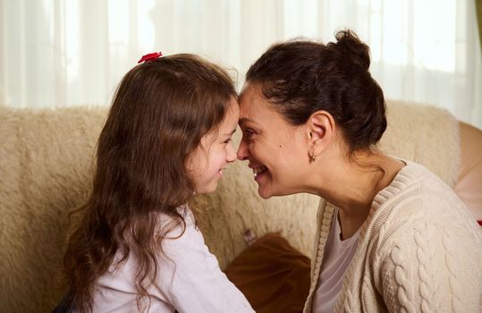 Happy beautiful woman, a loving mama spending time with her cute child girl, daughter, hugging, kissing. Mothers Day. International Children's Day. Concept of Love for family. Motherhood. Childhood