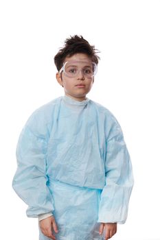 Vertical studio portrait on white background of handsome schoolboy wearing blue lab coat, confidently looking at camera, isolated on white background with advertising space for your promotional text