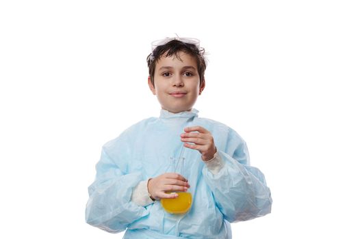 Confident portrait on white background of school kid, a smart teenage boy, young chemist scientist biologist in lab coat, holding a glass flask with chemicals and smiling looking at camera. Chemistry