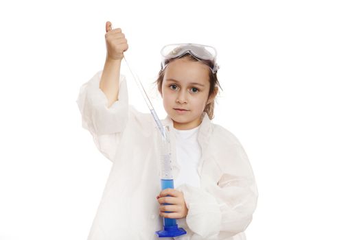 Smart preschooler child girl filling graduated pipette with blue substance from measuring cylinder, while conducting experiments in practical chemistry class, isolated over white background. Ad space