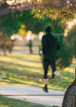 abstract blurred defocused view of young man runner training in nature. Selective focus.