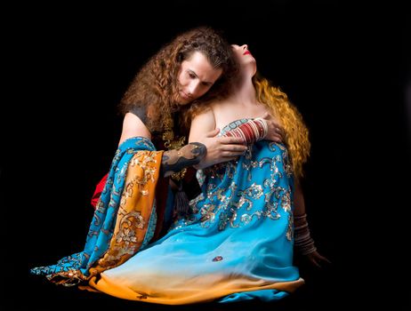 Young couple sit in indian dress in dark