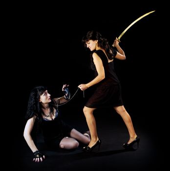 Two woman fight with sword on dark