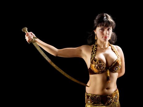 beautiful brunette woman stand with sword in dark