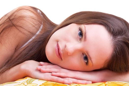 Young woman lay on color pillow slose-up portrait