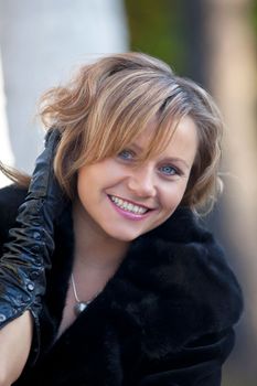 Beauty woman smile in fur coat look at you