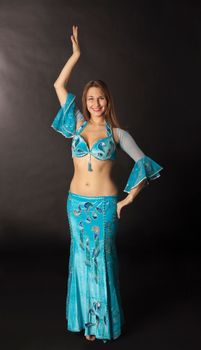 young woman dance and smile in blue arabian costume