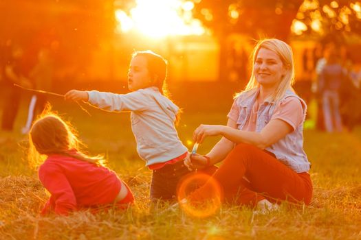 beautiful young mother and her daughter having fun at the field.