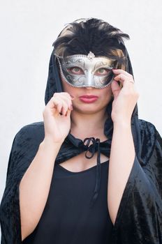 Mysterious Girl in a black cloak and a masquerade mask, mardi gras steampunk mask, a fairy tale, an enchanting story, High quality photo
