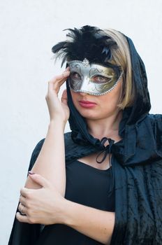 Mysterious Girl in a black cloak and a masquerade mask, mardi gras steampunk mask, a fairy tale, an enchanting story, High quality photo