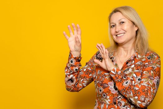 Caucasian beautiful woman wearing print dress over isolated yellow background laughing nervous and excited with hands up on one side