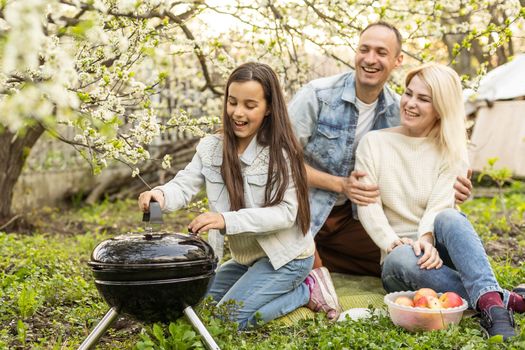 Happy family having barbecue with modern grill outdoors.