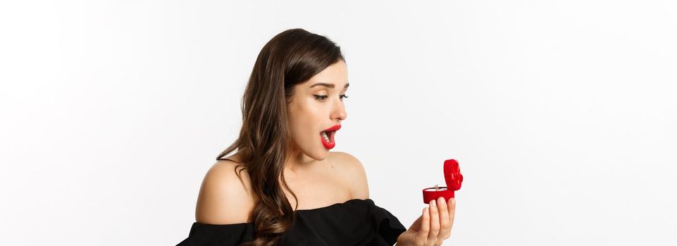 Close-up of surprised woman open box with engagement ring, looking amazed, receiving marriage proposal, girlfriend getting married.