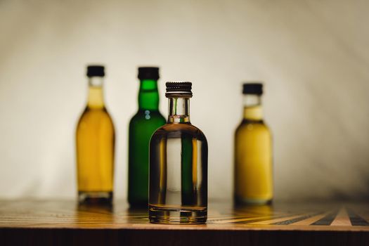 different alcohol bottles are on the table on a light background.