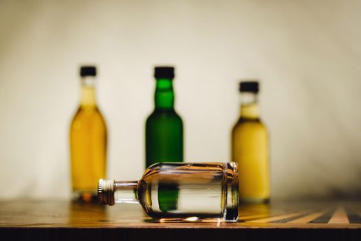 different alcohol bottles are on the table on a light background.