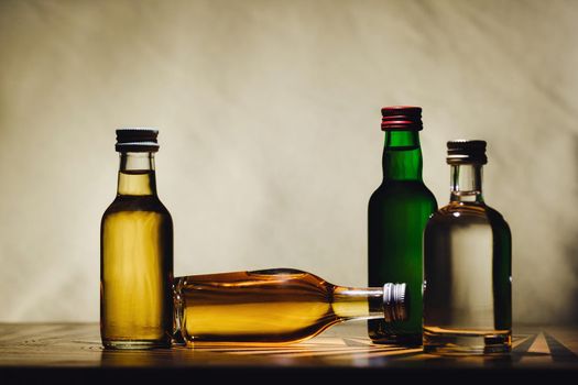 different alcohol bottles are on the table on a light background.