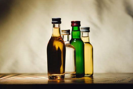 different alcohol bottles are on the table on a light background.