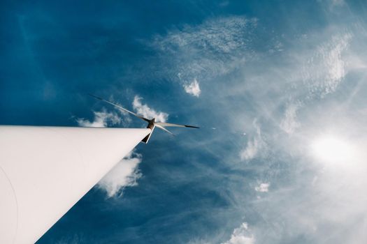 A white Windmill against a blue sky. Windmill in nature.