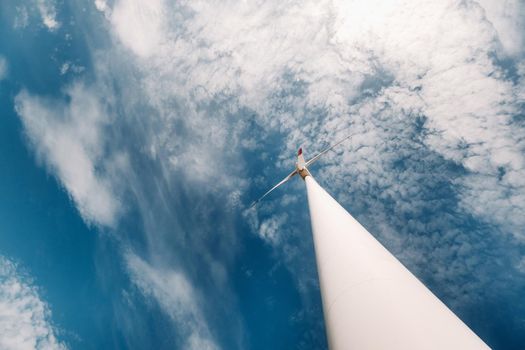 A white Windmill against a blue sky. Windmill in nature.