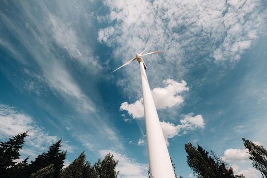 A white Windmill against a blue sky. Windmill in nature.